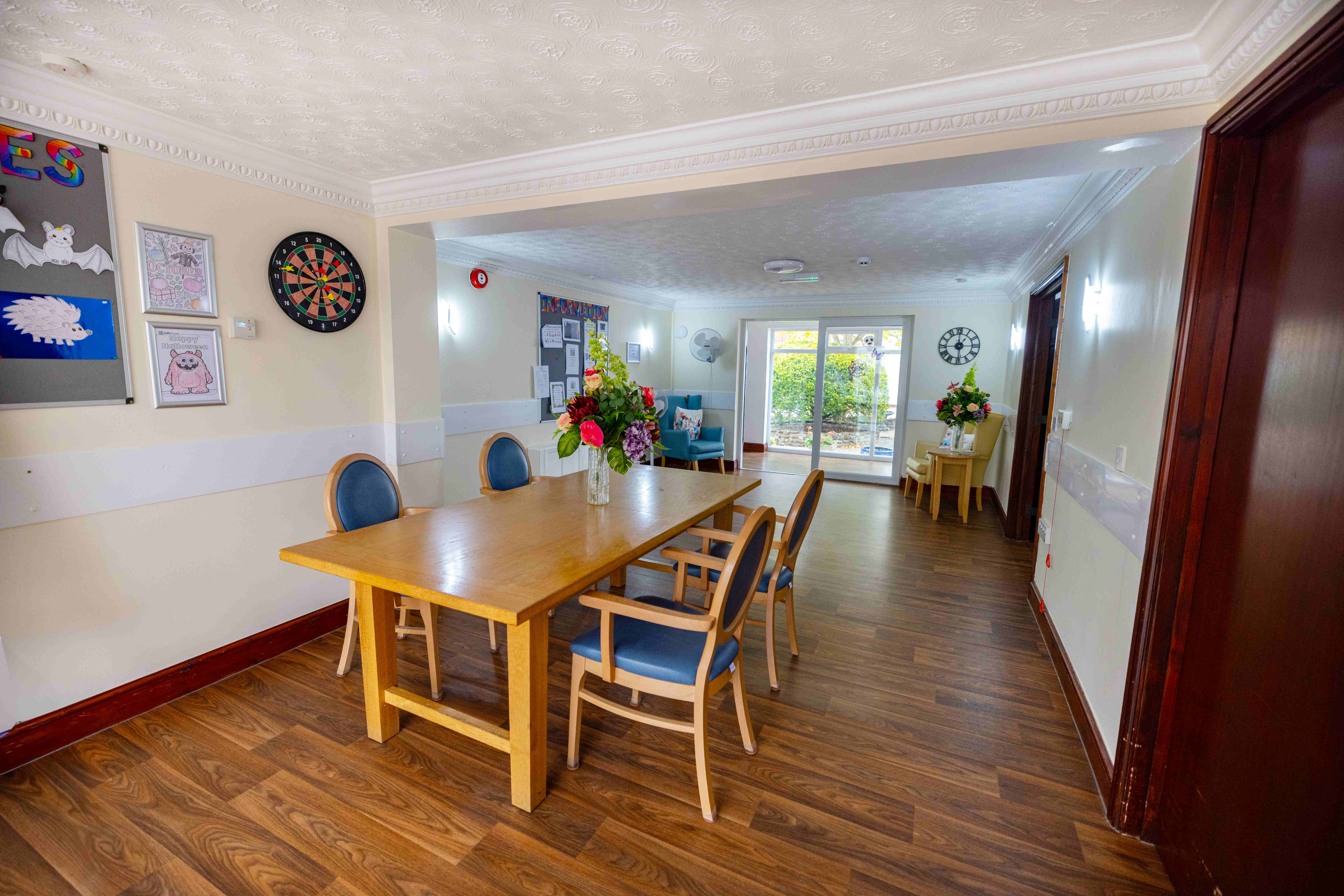 Spacious communal dining area with natural wood furniture and garden views