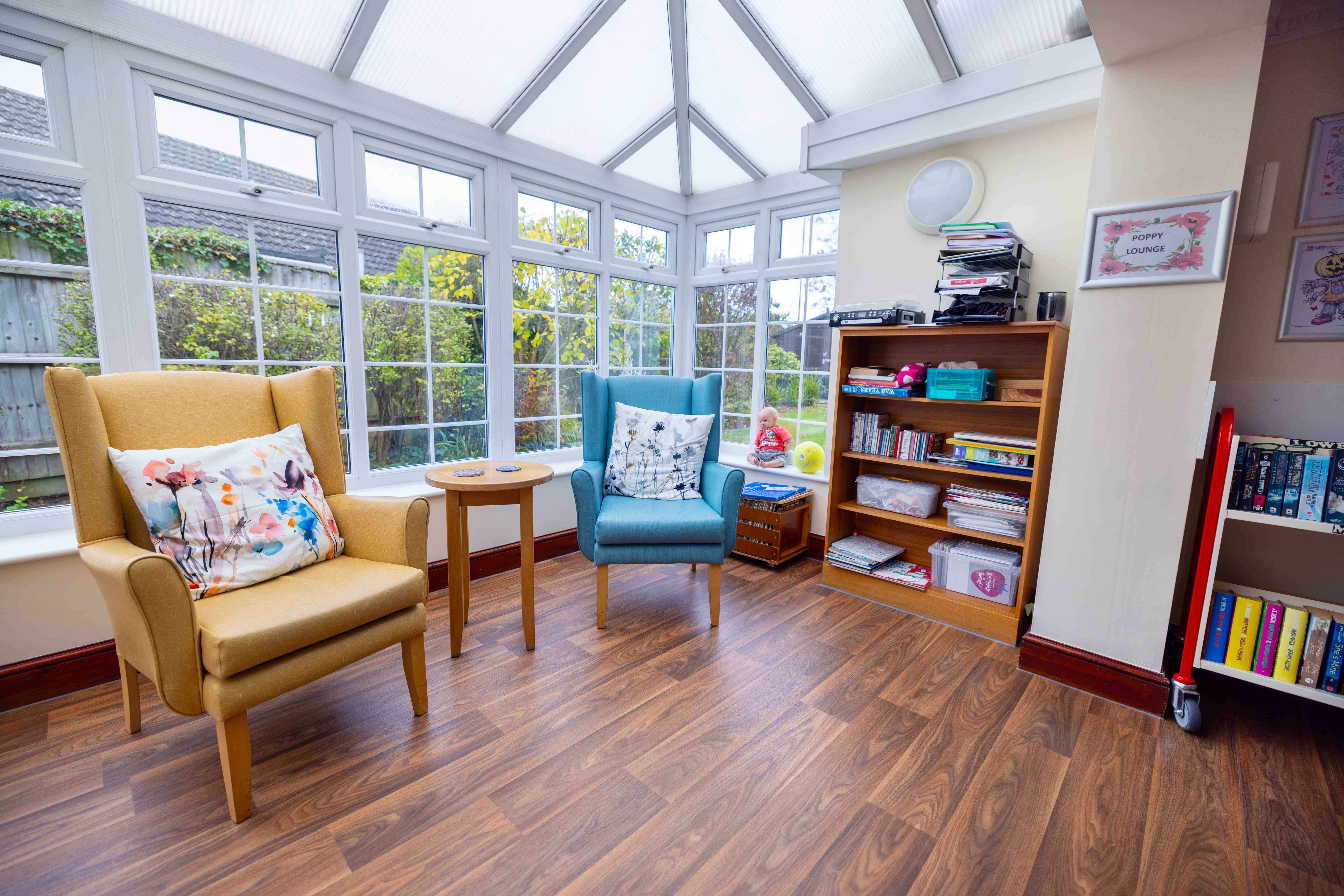 Bright Poppy Lounge conservatory with garden views and comfortable seating