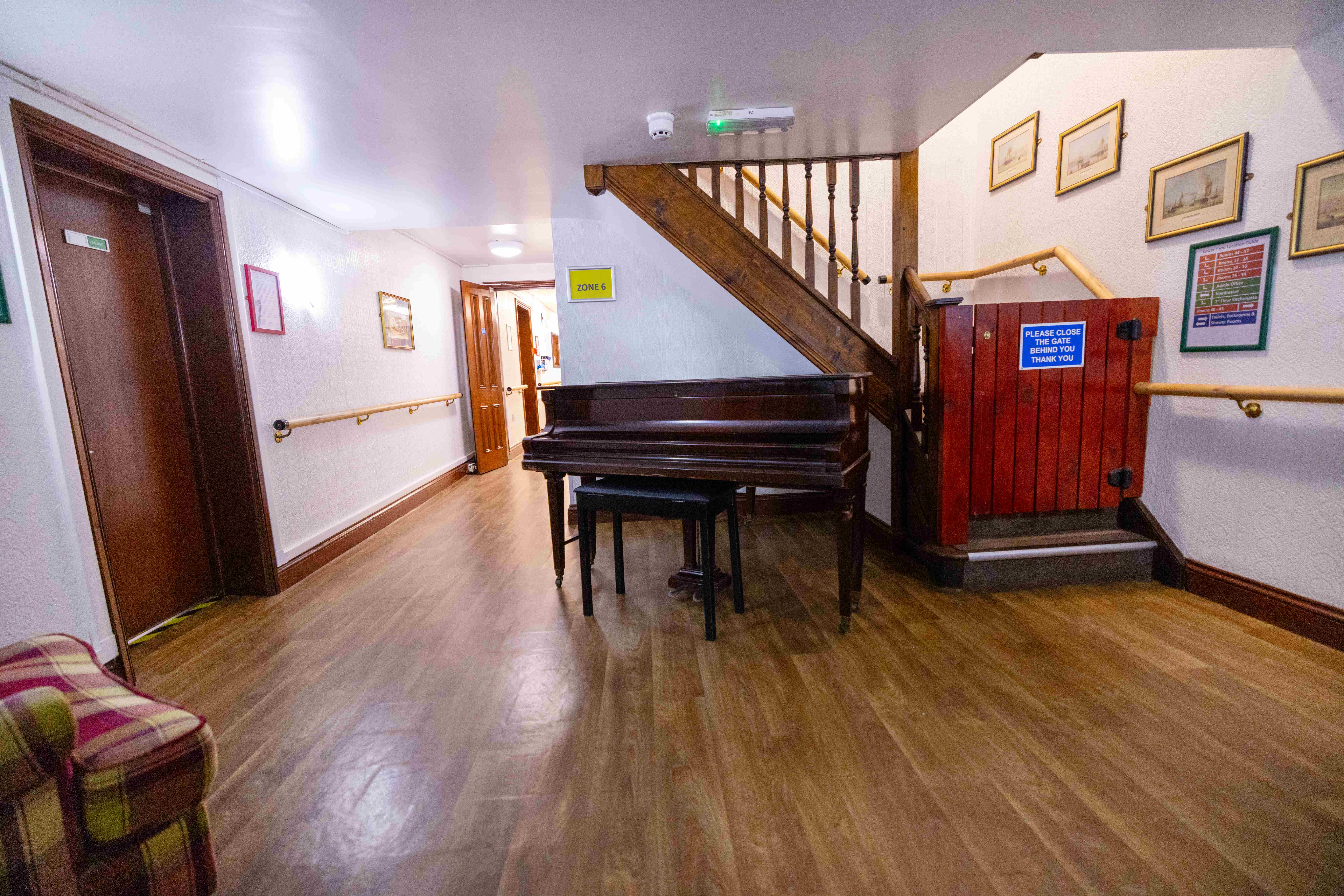 Elegant reception area with grand piano and traditional staircase